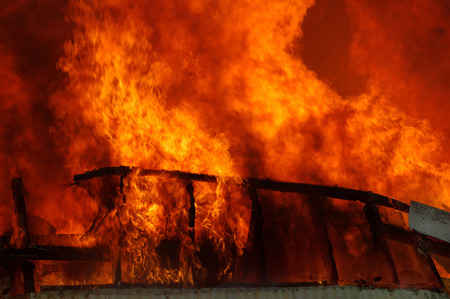 flames and smoke rise from burning farm buildingの写真素材