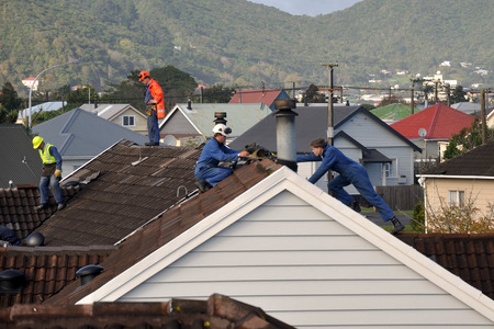 GREYMOUTH, NEW ZEALAND, APRIL 17, 2014: Volunteer workers replace tiles on a house damaged in Cobden by Cyclone Ita, Greymouth, New Zealand, April 17, 2014のeditorial素材