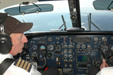 GREYMOUTH, NEW ZEALAND, CIRCA 2009: pilot checks the instruments in the cockpit of a Dornier 228 somewhere over the West Coast of the South Island, New Zealandのeditorial素材