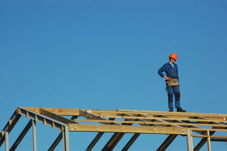 builder standing on top of roofing framework