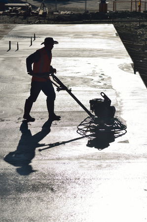 Silhouette of builder floating off concrete pad for a large buildingの写真素材