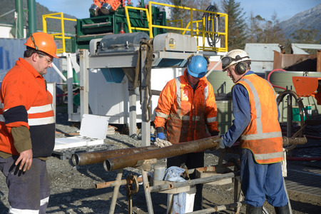 Drilling crewmen prepare to remove a core sample from a rig drilling near Greymouth, New Zealand.