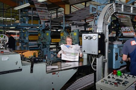 GREYMOUTH, NEW ZEALAND, MAY 22, 2015:  An unidentified woman bundles up newspapers as they are printed on May 22, 2015 in Greymouth, New Zealand.のeditorial素材