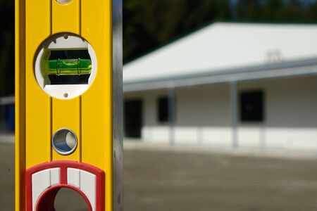 detail of the bubble in a spirit level with a new building in the backgroundの写真素材