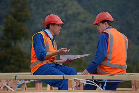Two electricians discuss the plan for a major construction job