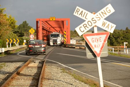 GREYMOUTH, NEW ZEALAND, APRIL 26, 2016: Traffic waits for oncoming vehicles to cross a single lane road-rail bridge over the Taramakau River near Greymouthのeditorial素材
