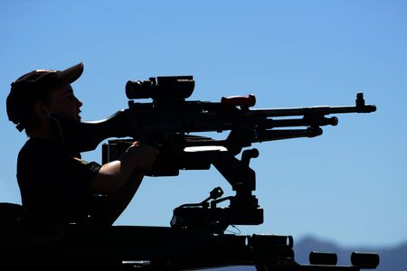 GREYMOUTH, NEW ZEALAND, NOVEMBER 18, 2017: An unidentified schoolboy lines up a Mag 58 GM machine gun at an open day run by the New Zealand armed forces.のeditorial素材