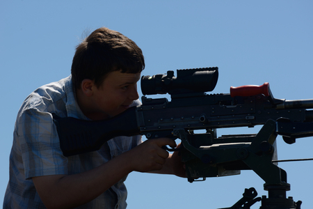 GREYMOUTH, NEW ZEALAND, NOVEMBER 18, 2017: An unidentified schoolboy lines up a Mag 58 GM machine gun at an open day run by the New Zealand armed forces.のeditorial素材