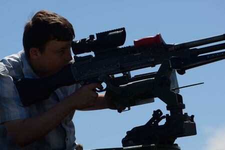 GREYMOUTH, NEW ZEALAND, NOVEMBER 18, 2017: An unidentified schoolboy lines up a Mag 58 GM machine gun at an open day run by the New Zealand armed forces.のeditorial素材