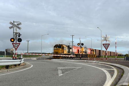 ARAHURA, NEW ZEALAND, AUGUST 29, 2020: A freight train crosses the main road at Arahura on State Highway 6.のeditorial素材