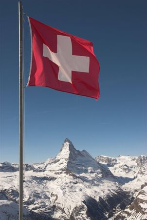  A mountaintop view of the national flag of Switzerland with the Matterhorn in the background  の写真素材