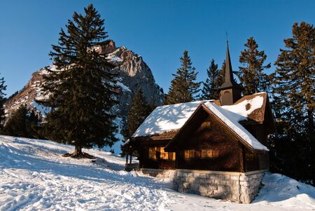 old wooden chapel in swiss alps in fron of the mythen mountain, switzerlandの写真素材