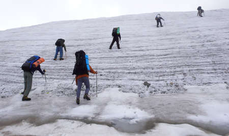 Six people trekking on a glacier. 