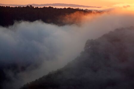 Misty morning of hilly area with ray of light.Russia, Ural.の写真素材