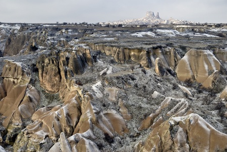 Sandstone formations in Zemi Valley near town Goreme, Cappadocia, Turkey. At the background town Uchisar.の写真素材