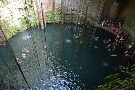 Many swimmeres in Ik-kil cenote in Yucatan peninsula, Mexico. 09.01.2016. This cenote is 4 km from Mayan site Chichen Itza in Yucatan peninsula, Mexico.のeditorial素材