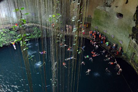 Many swimmeres in Ik-kil cenote in Yucatan peninsula, Mexico. 09.01.2016. This cenote is 4 km from Mayan site Chichen Itza in Yucatan peninsula, Mexico.のeditorial素材