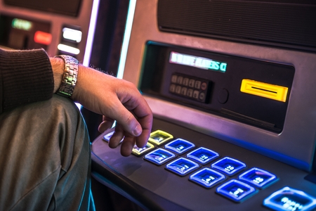 Frustrated Men Playing Slot Machine. Gambling Problem Concept.の写真素材