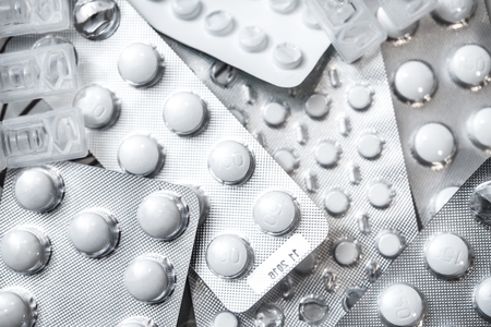 Pile of Drugs Closeup Photo. White Pills in a Silver Packaging Photo.の写真素材