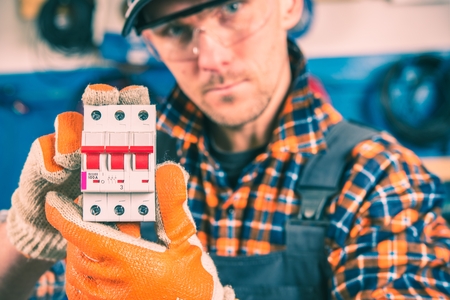 Worker with Electric Switcher in Hands. Closeup Photo. Switcher Production.の写真素材