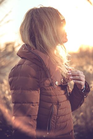 Beauty shot of a woman in the field at the sunset.の写真素材