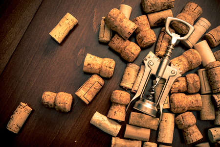 Corkscrew and wine corks on wooden table backgroundの写真素材