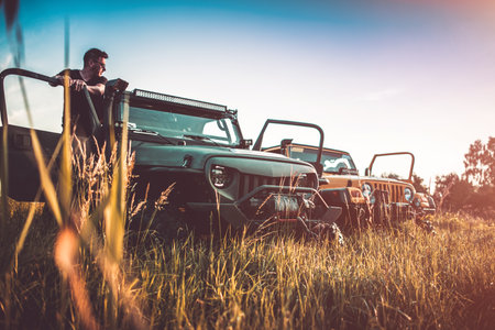 Two Off-Road Vehicles Parked in the Field in the Sunshine. Drivers Taking a Break During Their Recreational All-Terrain Ride.の写真素材