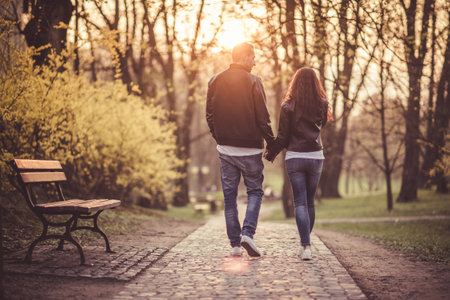 Couple holding hands walking towards sunset. Love theme. Relationship.の写真素材