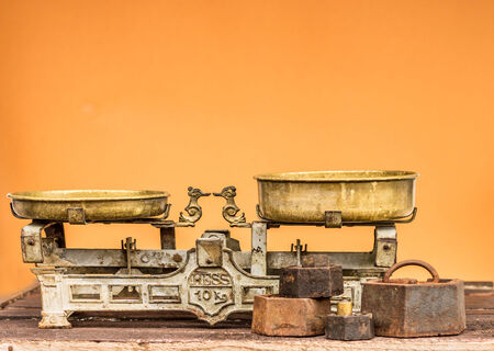 old rustic balance with weights orange backgroundの写真素材