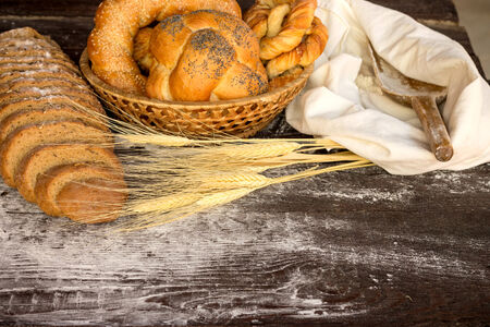 Bakery products in wicker basket on a wooden tableの写真素材