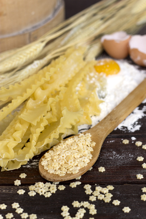 Various pasta types on a wooden tableの写真素材
