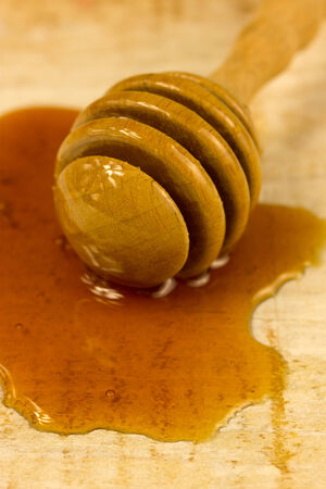 puddle of honey with wooden stickの写真素材