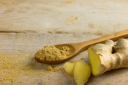 powder ginger spice and fresh ginger on a wooden backgroundの写真素材