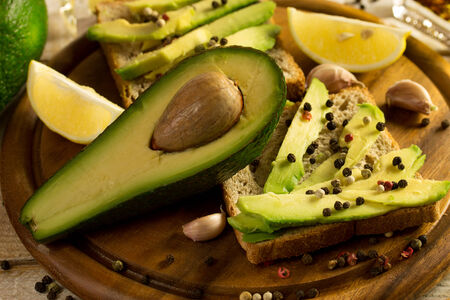 Avocado sandwich with lemon and garlic on a cutting boardの写真素材