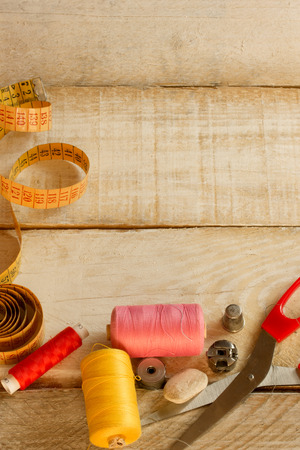 Tools for sewing and handmade: thread, scissor, pins on wooden tableの写真素材
