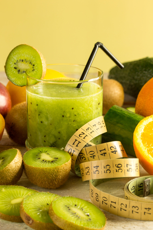 kiwi smoothie with different fruits on a wooden tableの写真素材