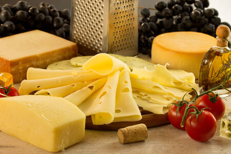 assortment of grapes and cheese on a wooden surfaceの写真素材