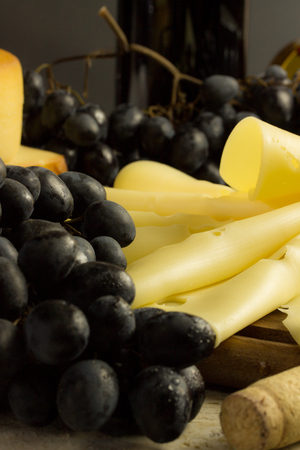grapes and cheese on a cutting boardの写真素材