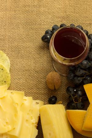 various cheese and red wine over a canvas backgroundの写真素材