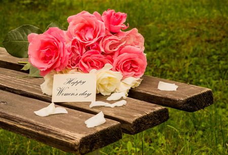 pink roses on a wooden bench for women's dayの写真素材