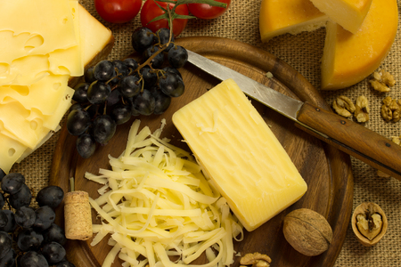 cheese with grape and nuts on a cutting boardの写真素材
