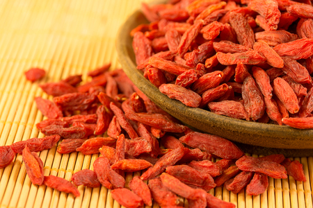 closeup of goji berries on a wooden bowlの写真素材