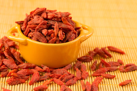 Dried Tibetan goji berries in ceramic bowlの写真素材