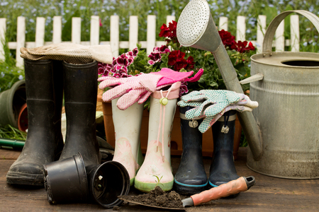 gardening tools adult and child boots and handshoes in the gardenの写真素材