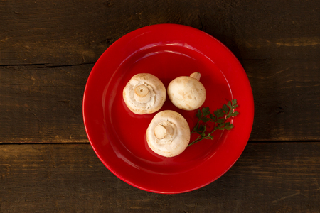 champignon mushrooms over a red plateの写真素材
