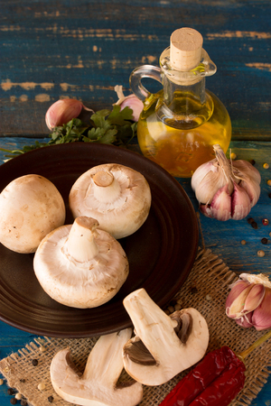 fresh mushroom with garlic,oil,pepper on a blue wooden tableの写真素材