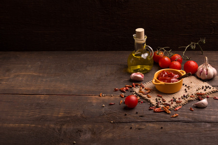 tomato sauce and ingredients over dark wooden tableの写真素材