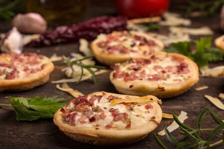 mini pizzas with ingerdients on dark wooden surfaceの写真素材