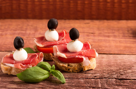 sandwiches of mozzarella cheese, bacon, tomato and basilの写真素材