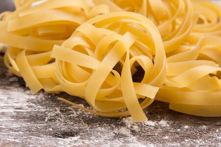 close up of egg pasta nest on a rustic tableの写真素材